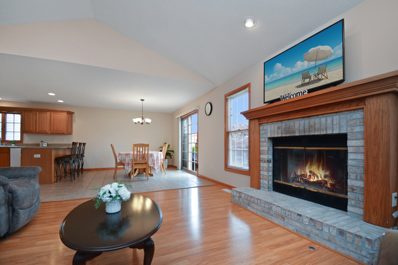 2884 Bear Claw Street Normal, IL 61761 - Photo 8 of 62 a living room with furniture a fireplace a dining table and kitchen view