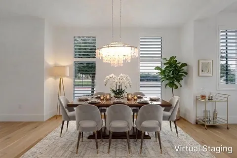 a dining room with furniture potted plants and wooden floor