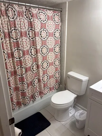 a white toilet sitting next to a shower curtain