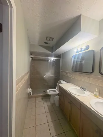 a bathroom with a double vanity sink toilet and a mirror