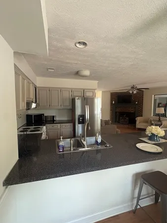 a kitchen with kitchen island granite countertop a sink counter top space and stainless steel appliances