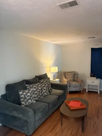 a living room with furniture and a wooden floor