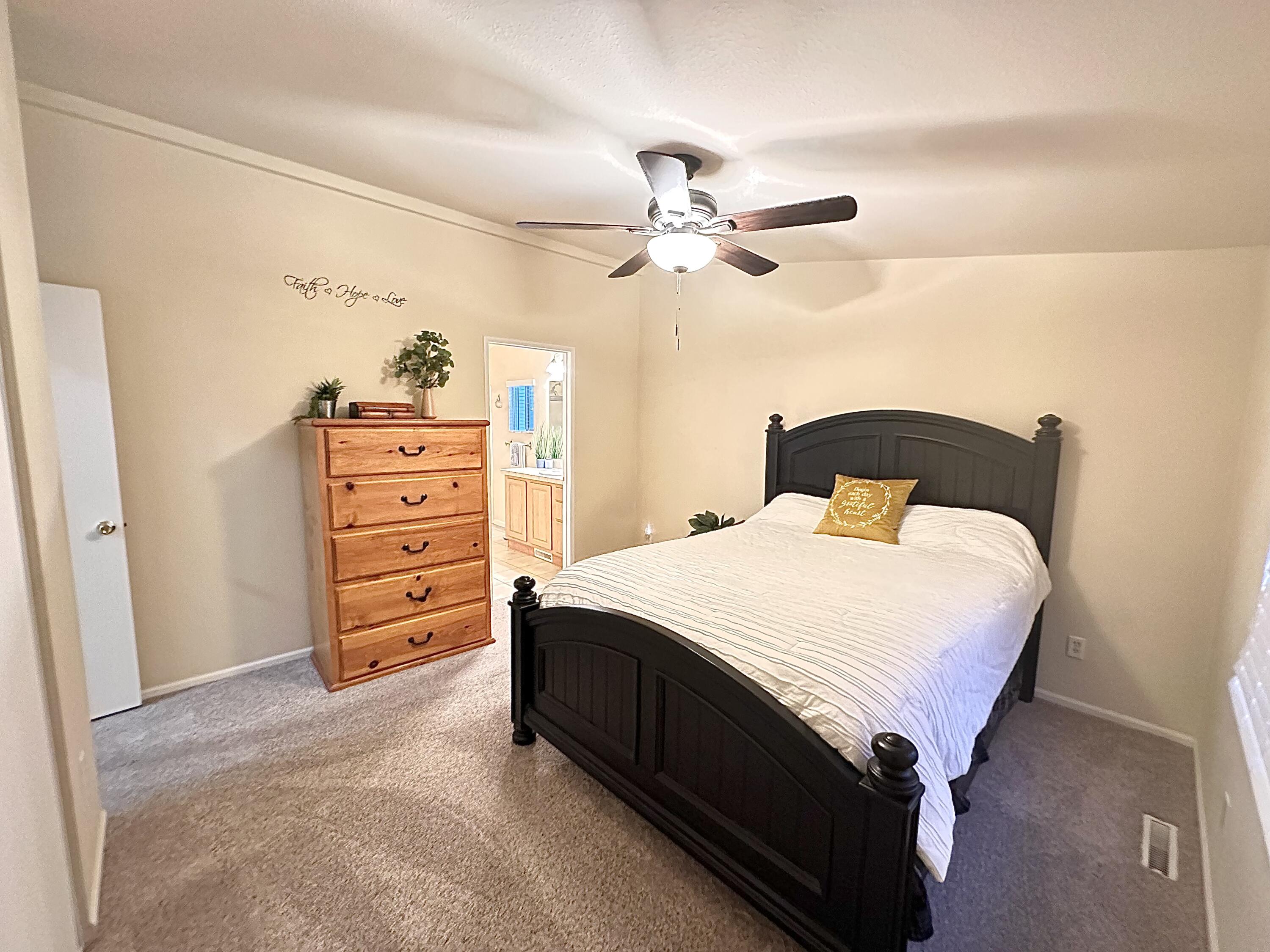 4713 Maple Trail, Unit LOS ROBLES ESTATES Redding, CA 96003 - Photo 16 of 22 a bedroom with a bed and ceiling fan