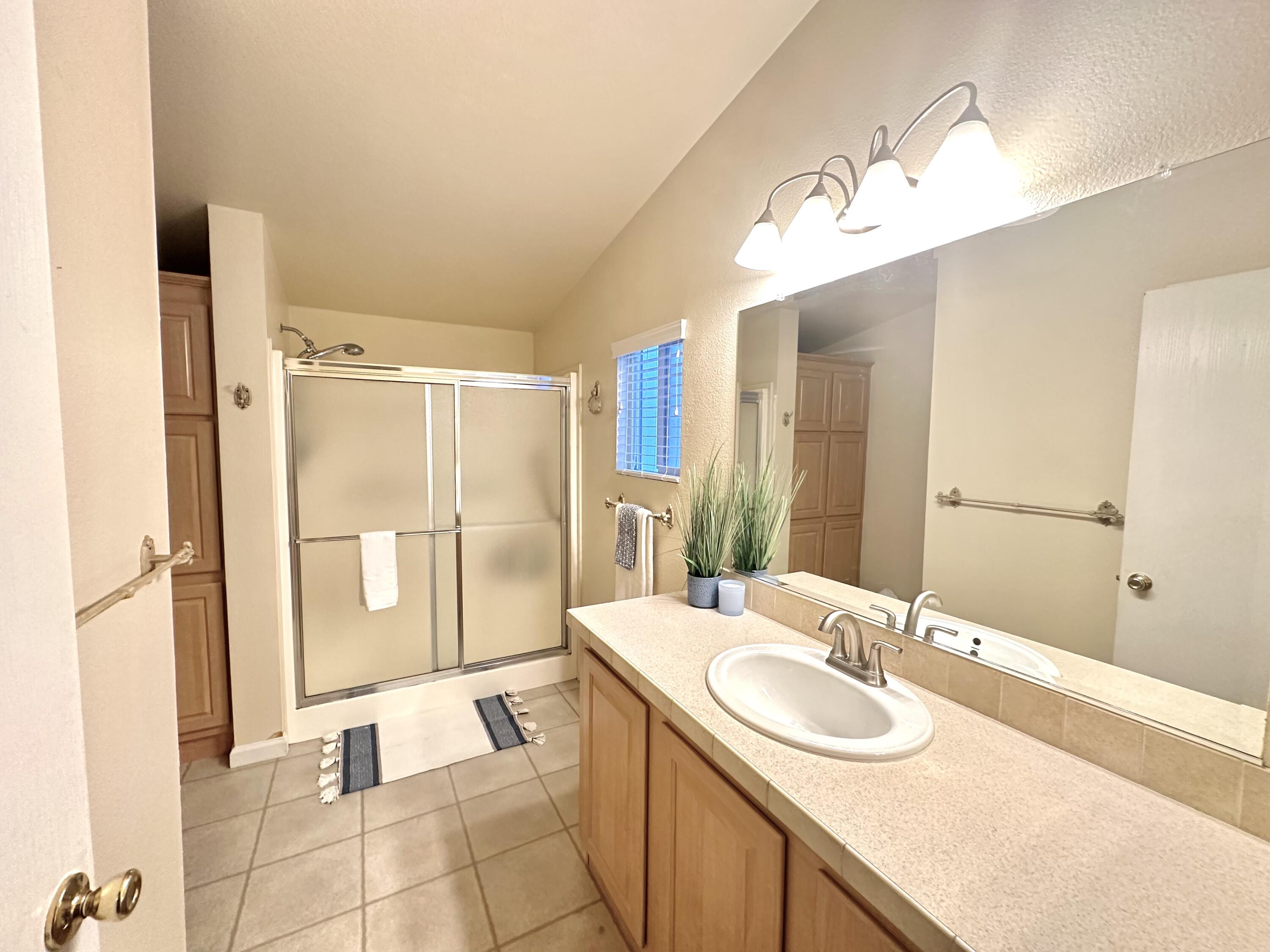 4713 Maple Trail, Unit LOS ROBLES ESTATES Redding, CA 96003 - Photo 17 of 22 a bathroom with a sink double vanity and a mirror