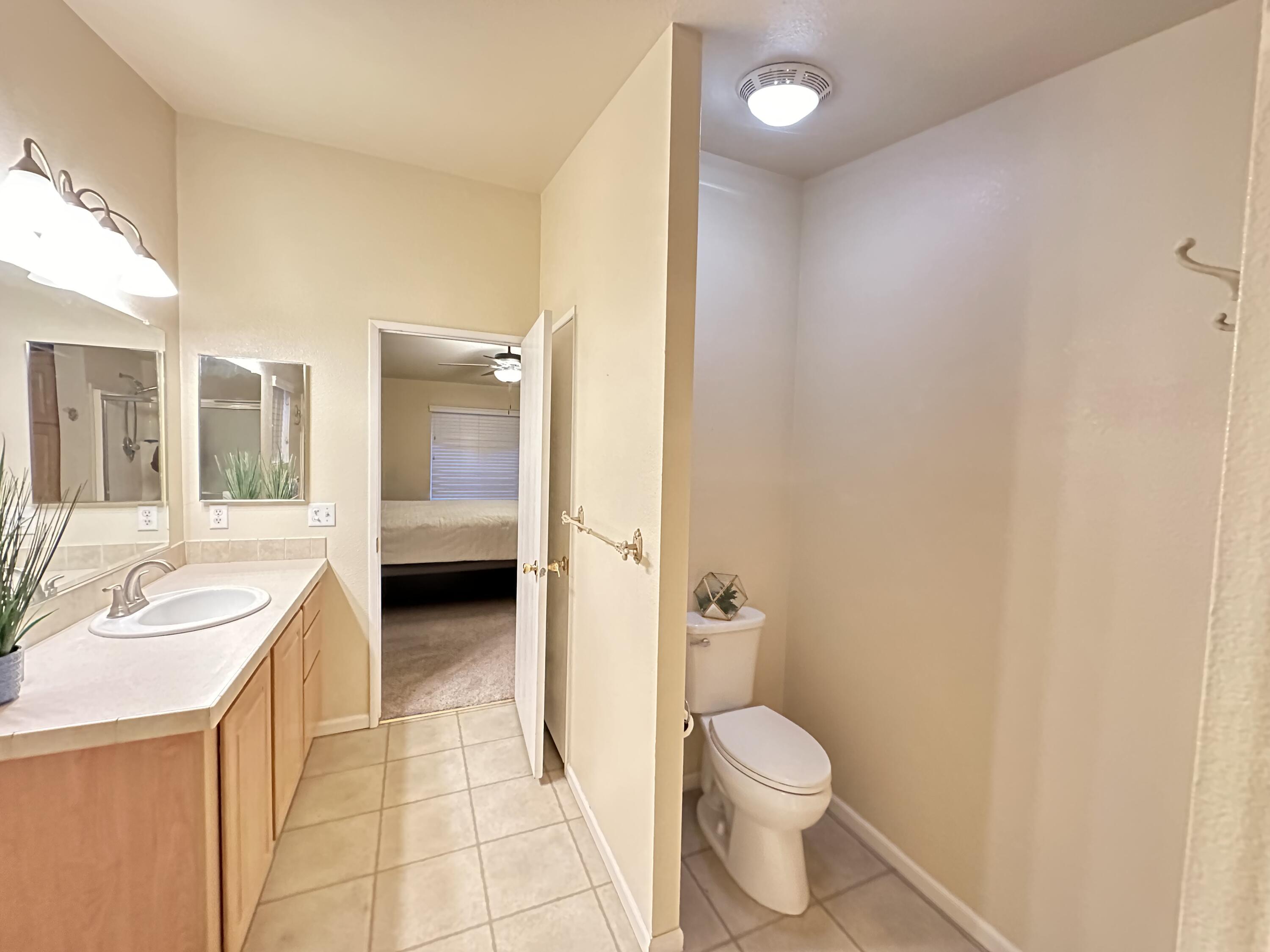 4713 Maple Trail, Unit LOS ROBLES ESTATES Redding, CA 96003 - Photo 19 of 22 a bathroom with a granite countertop sink toilet and shower