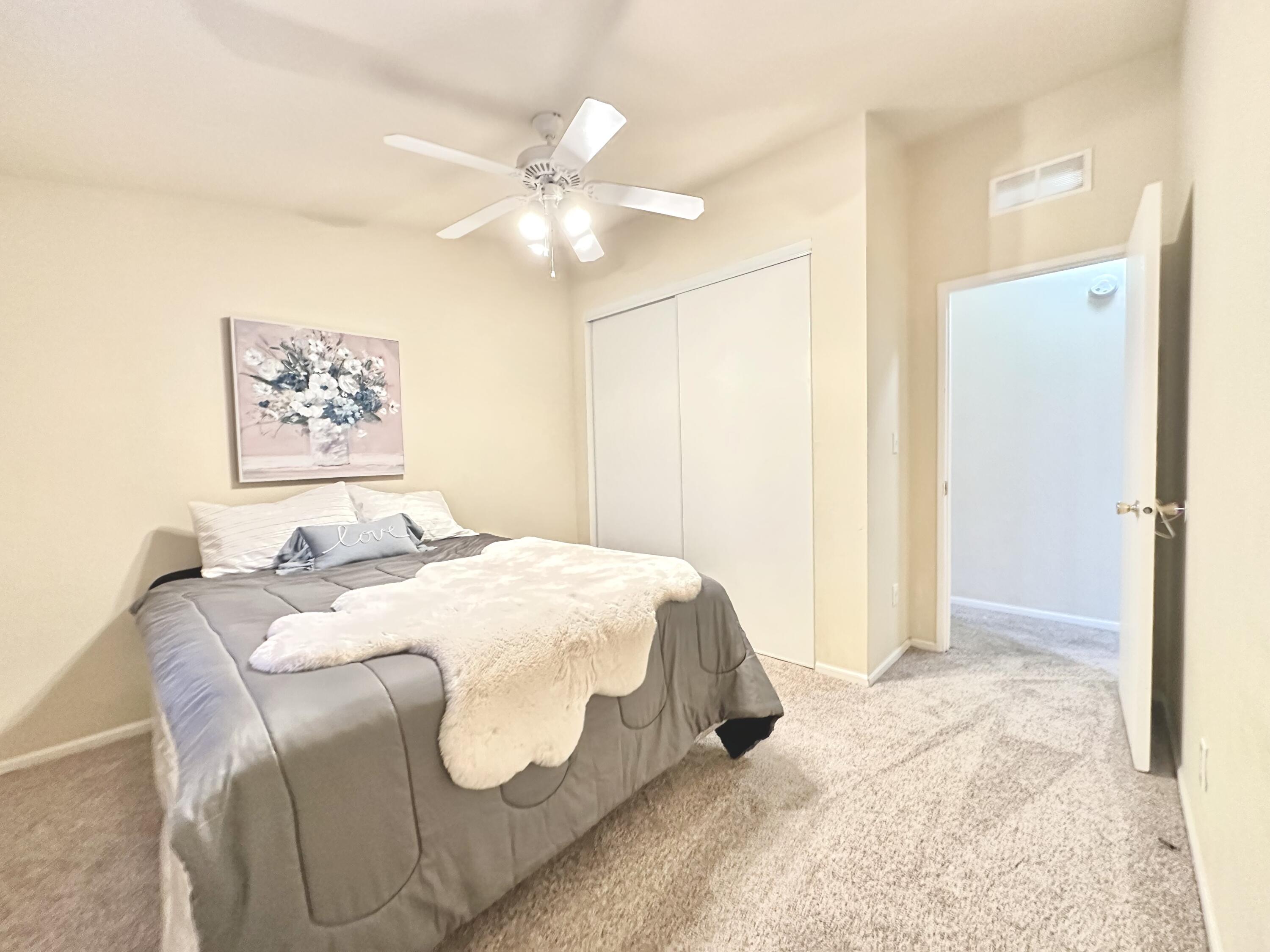 4713 Maple Trail, Unit LOS ROBLES ESTATES Redding, CA 96003 - Photo 20 of 22 a bedroom with a bed and a chandelier