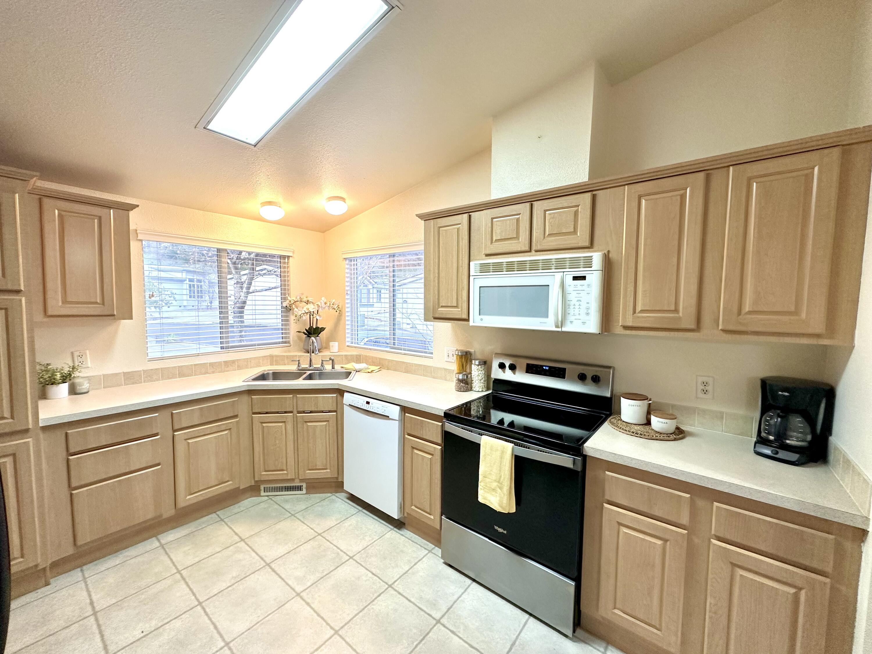 4713 Maple Trail, Unit LOS ROBLES ESTATES Redding, CA 96003 - Photo 9 of 22 a kitchen with stainless steel appliances granite countertop a stove sink and cabinets