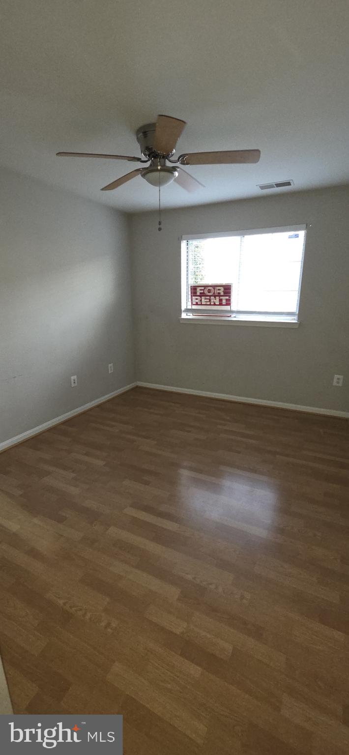 11192 Rienzi Place, Unit 102 Manassas, VA 20109 - Photo 14 of 19 an empty room with wooden floor and windows