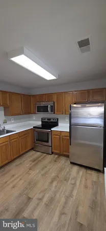 a kitchen with stainless steel appliances kitchen island granite countertop a stove and a sink