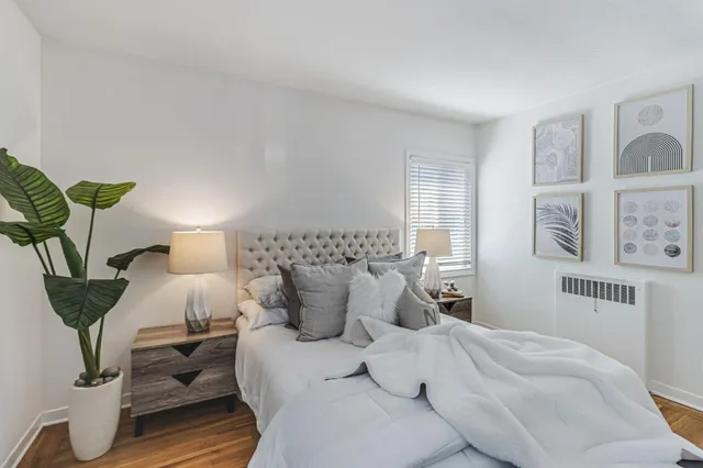 a bedroom with a bed and wooden floor