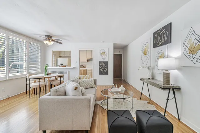 a dining room with kitchen island stainless steel appliances furniture a fireplace and a chandelier