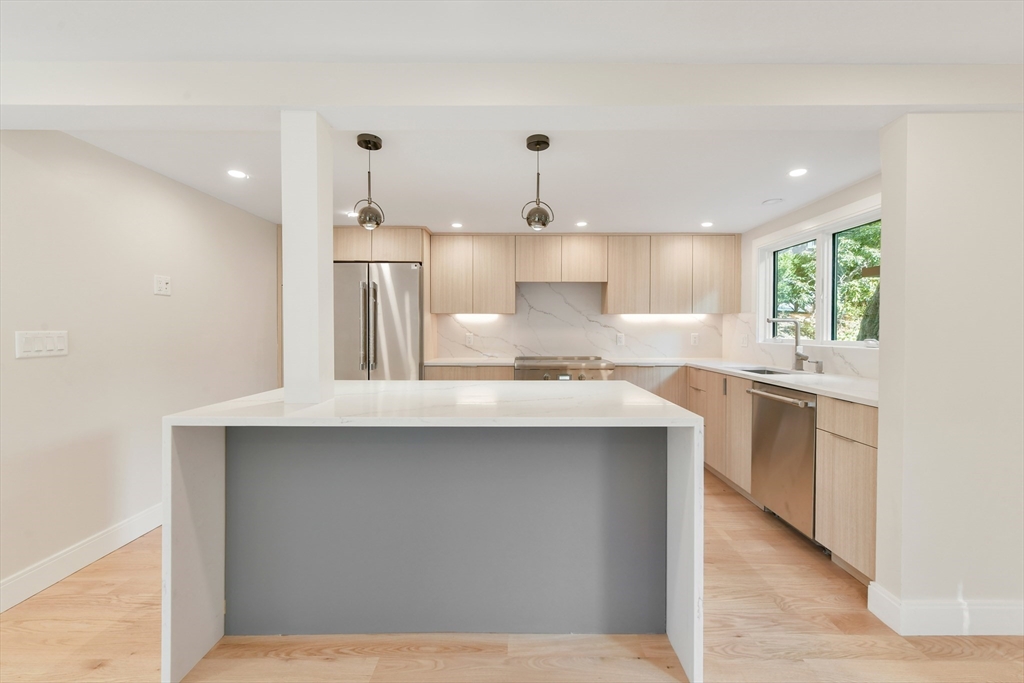 72 Wallis Road Brookline, MA 02467 - Photo 14 of 42 a kitchen with kitchen island a sink stainless steel appliances and cabinets