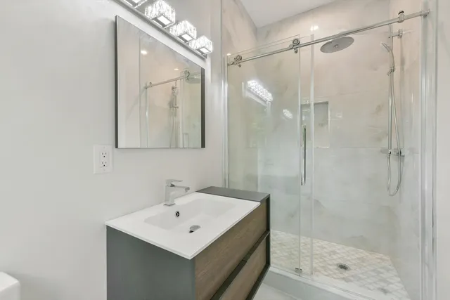 a bathroom with a shower a sink and mirror