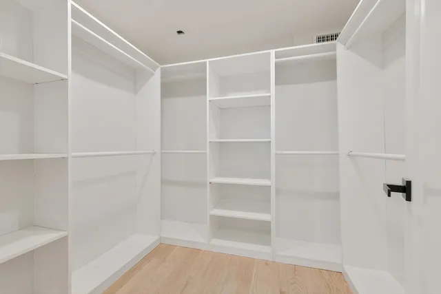 a view of walk in closet with empty racks
