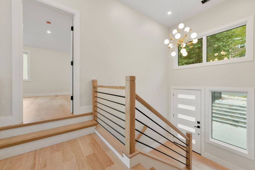 72 Wallis Road Brookline, MA 02467 - Photo 6 of 42 a view of a hallway with a window and chandelier