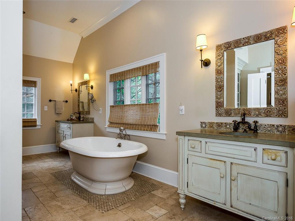 728 Berkeley Avenue Charlotte, NC 28203 - Photo 15 of 24 a bathroom with a double vanity sink a mirror and a bathtub