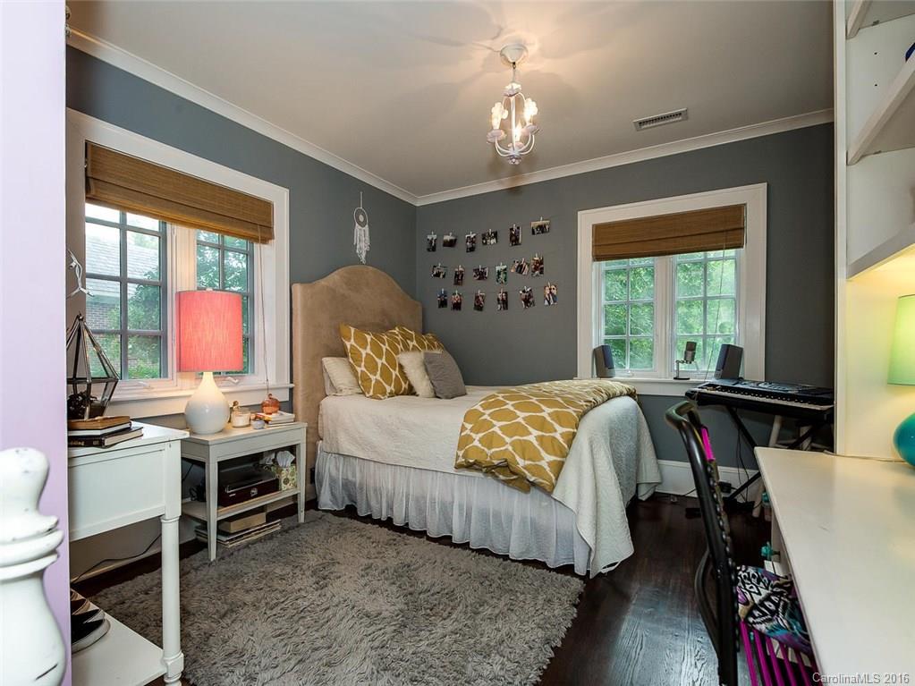 728 Berkeley Avenue Charlotte, NC 28203 - Photo 19 of 24 a bedroom with a bed and a chandelier