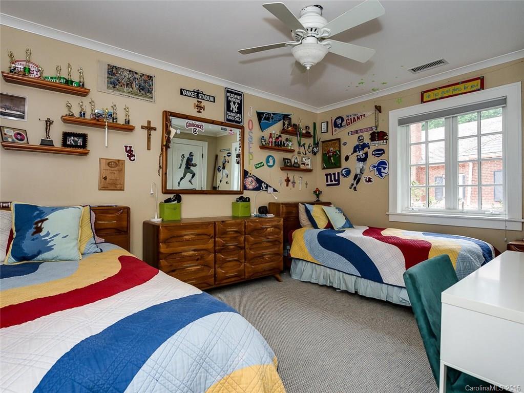 728 Berkeley Avenue Charlotte, NC 28203 - Photo 20 of 24 a bedroom with a bed and a chandelier