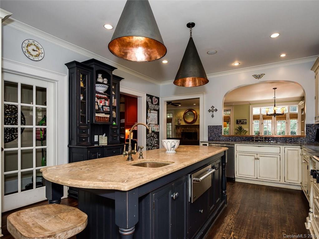 728 Berkeley Avenue Charlotte, NC 28203 - Photo 8 of 24 a kitchen with a stove a sink a kitchen island with wooden cabinets and floor