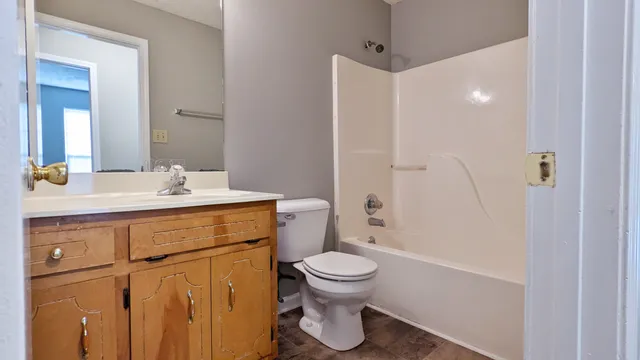 a bathroom with a sink toilet vanity and shower