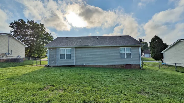 a aerial view of a house next to a yard and large trees