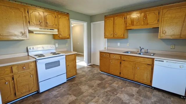 a kitchen with a sink stove top oven and cabinets