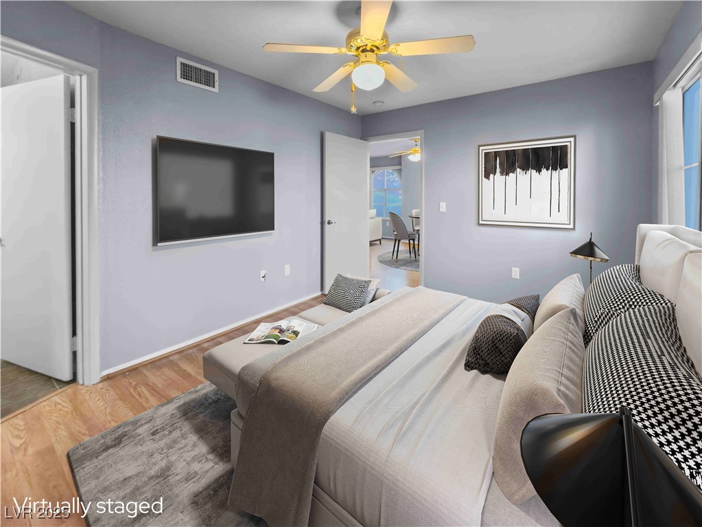 7950 West Flamingo Road, Unit 1169 Las Vegas, NV 89147 - Photo 2 of 42 Primary bedroom with ensuite & ceiling fan. Virtually staged