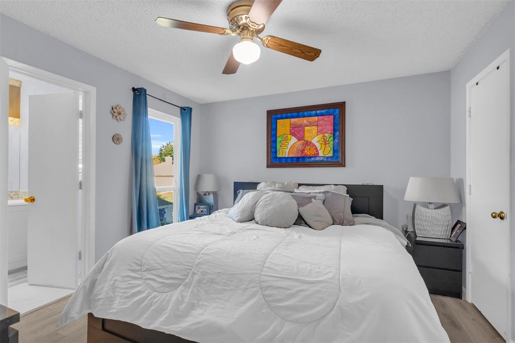 7670 Kings Ridge Road Frisco, TX 75035 - Photo 15 of 24 Bedroom with light wood-style floors, a ceiling fan, and a textured ceiling