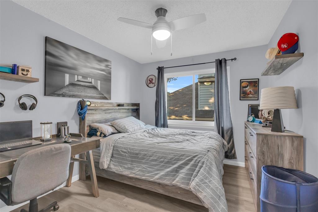 7670 Kings Ridge Road Frisco, TX 75035 - Photo 18 of 24 Bedroom with light wood finished floors, a desk, a textured ceiling, and ceiling fan