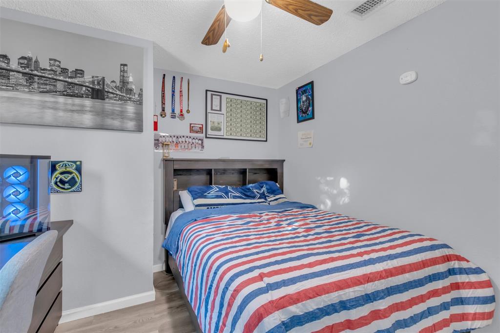 7670 Kings Ridge Road Frisco, TX 75035 - Photo 22 of 24 Bedroom with a textured ceiling, wood finished floors, and a ceiling fan