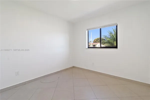 an empty room with a painting on the wall