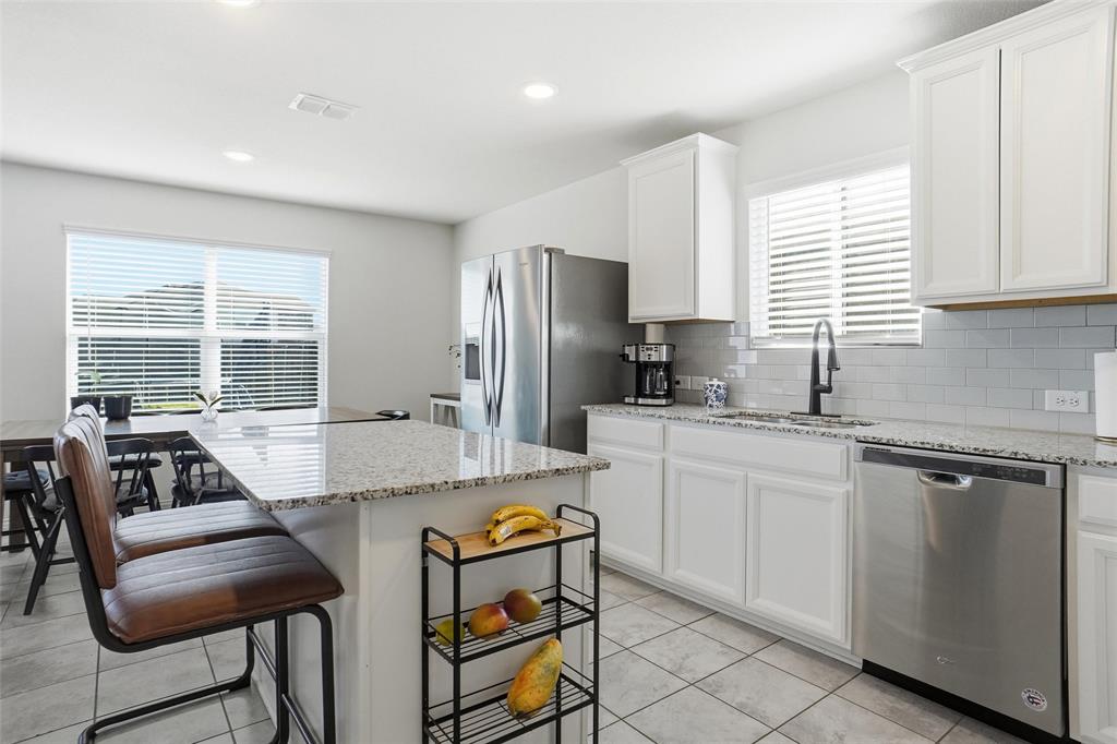 1719 Ackerly Drive Forney, TX 75126 - Photo 1 of 27 a kitchen with stainless steel appliances granite countertop a stove a sink dishwasher a refrigerator and white cabinets with wooden floor