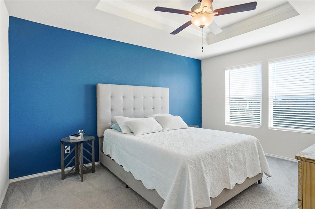 1719 Ackerly Drive Forney, TX 75126 - Photo 13 of 27 a bedroom with a bed and a chandelier