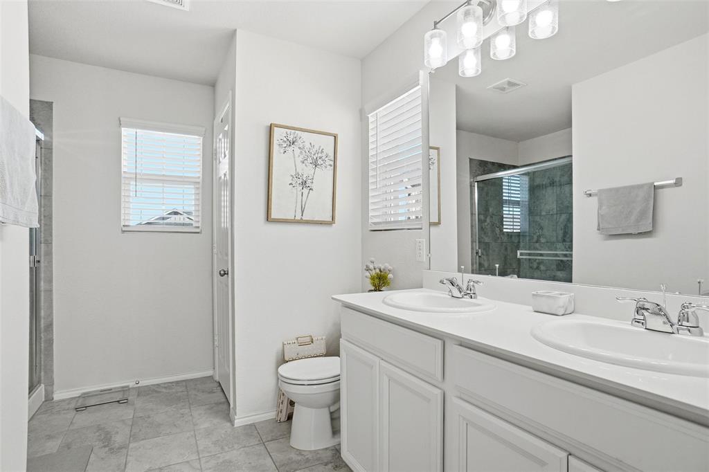 1719 Ackerly Drive Forney, TX 75126 - Photo 15 of 27 a bathroom with a toilet a sink and mirror