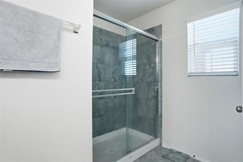 1719 Ackerly Drive Forney, TX 75126 - Photo 16 of 27 a bathroom with a glass shower door