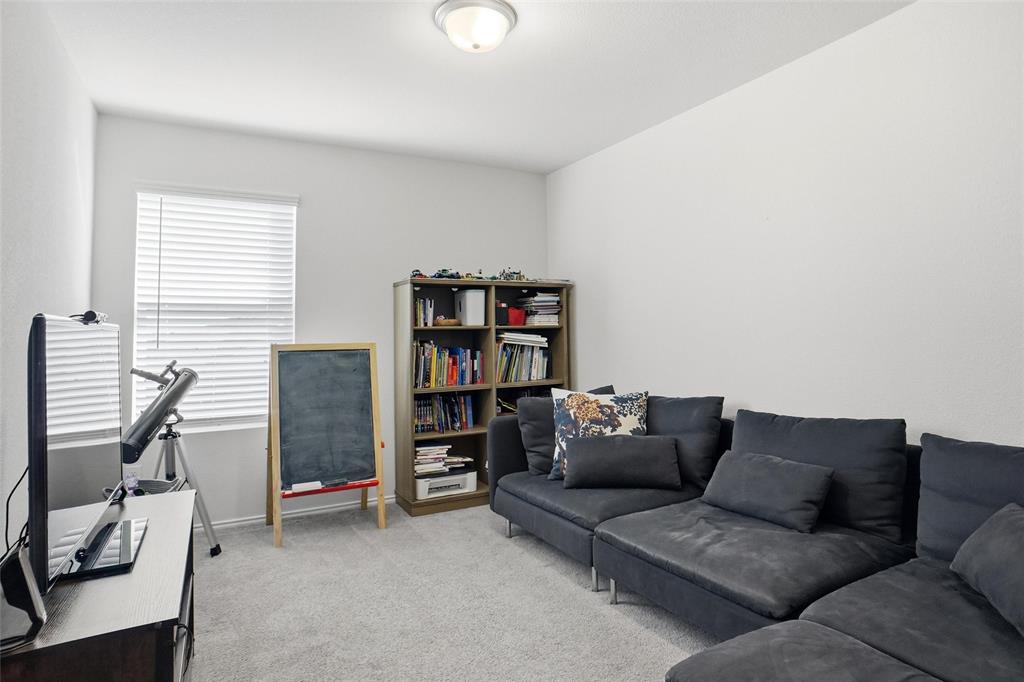 1719 Ackerly Drive Forney, TX 75126 - Photo 19 of 27 a living room with furniture and a book shelf