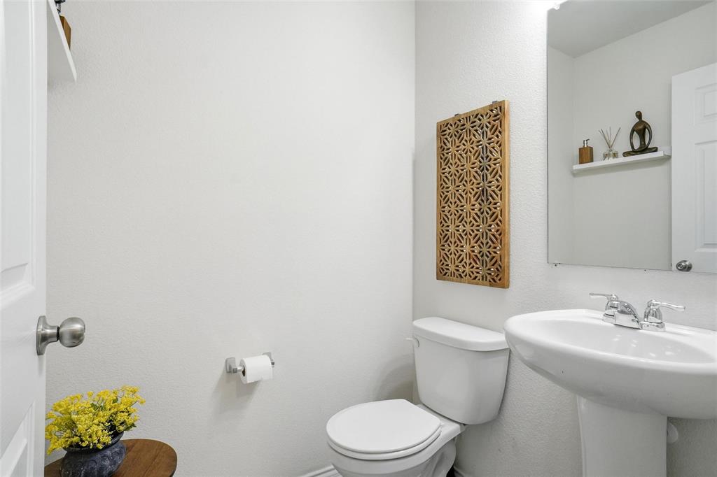 1719 Ackerly Drive Forney, TX 75126 - Photo 21 of 27 a bathroom with a toilet a sink and mirror