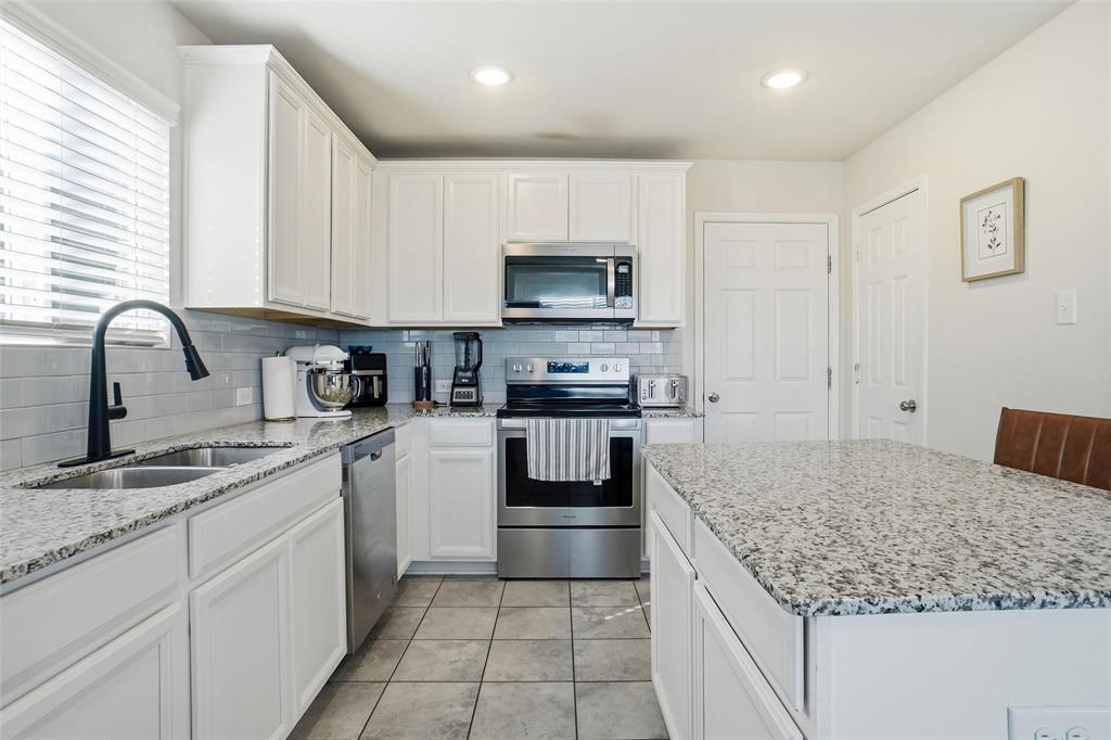 1719 Ackerly Drive Forney, TX 75126 - Photo 4 of 27 a kitchen with a sink stove and cabinets