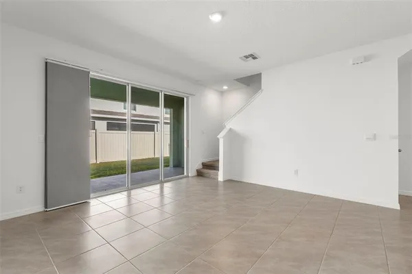 an empty room with floor to ceiling window and an empty room
