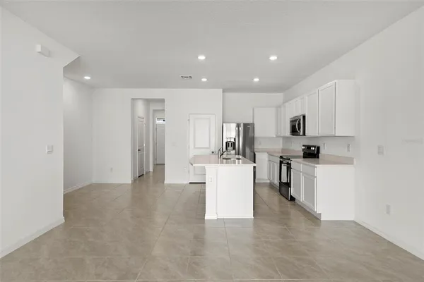 a open kitchen with white cabinets and stainless steel appliances