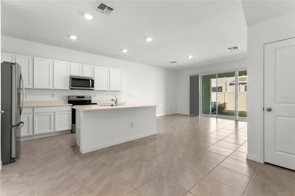 a kitchen with granite countertop a stove a sink and a refrigerator
