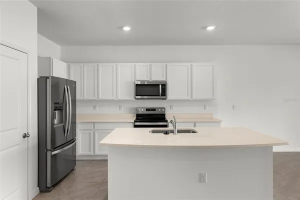 a kitchen with a refrigerator a stove a microwave and cabinets