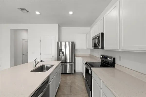 a kitchen that has a sink cabinets counter space and stainless steel appliances