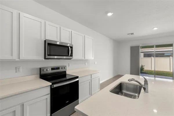 a kitchen that has a sink and a stove top oven