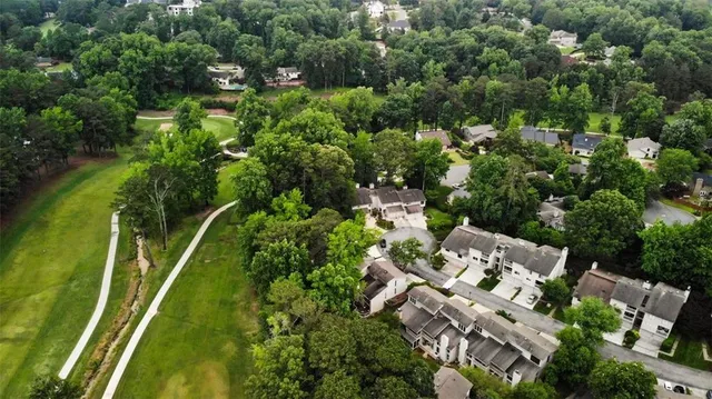 an aerial view of residential houses with outdoor space and trees