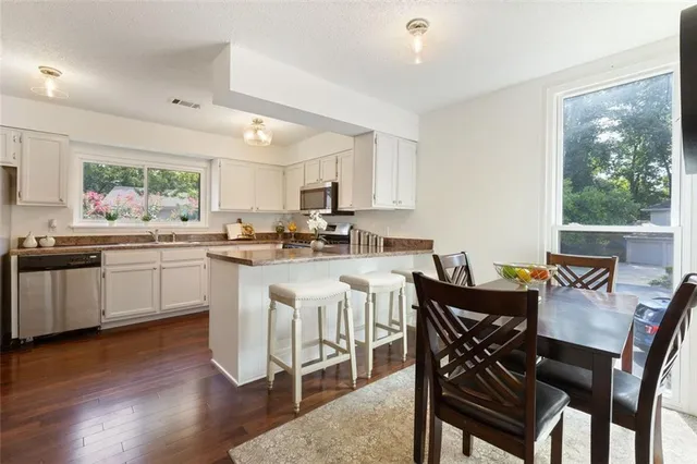 a kitchen with a table chairs sink and cabinets