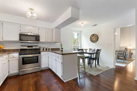 a kitchen with a sink cabinets and wooden floor