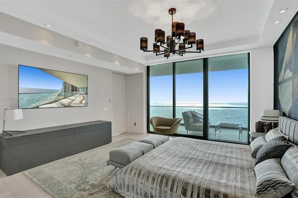 a bedroom with a bed and a flat tv screen on dresser