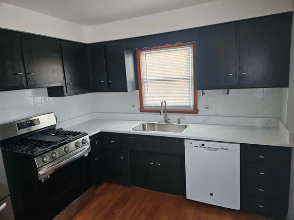 a kitchen with a sink stove top oven and cabinets