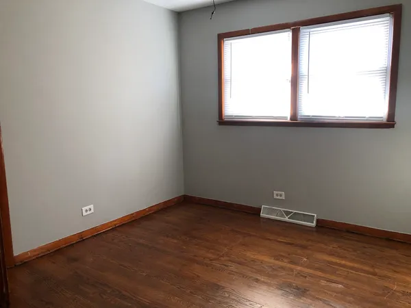 an empty room with wooden floor and a window